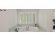 Soaking tub nestled beneath a window in a serene bathroom setting at 1407 Becklow Ct, Wesley Chapel, NC 28079
