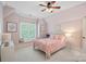 Pink bedroom with a white iron bed frame, neutral carpet and natural light at 1407 Becklow Ct, Wesley Chapel, NC 28079