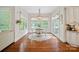Bright dining area featuring a chandelier, large windows overlooking a garden view, and hardwood floors at 1407 Becklow Ct, Wesley Chapel, NC 28079