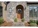 Elegant stone entryway with arched doorway and beautifully stained wood door at 1407 Becklow Ct, Wesley Chapel, NC 28079