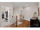 Upper hallway with hardwood floors leads to the staircase, gym, and a serene living space at 1407 Becklow Ct, Wesley Chapel, NC 28079