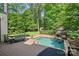 Backyard pool and spa area with an outdoor fireplace and lounge chairs at 1407 Becklow Ct, Wesley Chapel, NC 28079