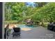 Backyard pool with an outdoor stone fireplace and wood deck at 1407 Becklow Ct, Wesley Chapel, NC 28079