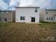 The backyard features a grassy area and the home's exterior with a sliding glass door at 14217 Wilson Mac Ln, Charlotte, NC 28278