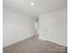 A bedroom with neutral carpeting, white walls and doors with a hallway view at 14217 Wilson Mac Ln, Charlotte, NC 28278