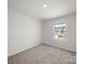 Well-lit bedroom with large window, neutral walls, and soft carpet flooring at 14217 Wilson Mac Ln, Charlotte, NC 28278