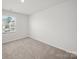 Neutral bedroom with a window providing natural light and cozy carpeting at 14217 Wilson Mac Ln, Charlotte, NC 28278