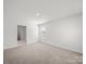A bedroom featuring neutral carpeting, white walls, a window and an open door leading to a closet at 14217 Wilson Mac Ln, Charlotte, NC 28278