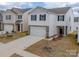 Charming two-story home with white siding, stone accents, a two-car garage, and a well-maintained lawn at 14217 Wilson Mac Ln, Charlotte, NC 28278