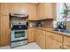 The kitchen features stainless steel appliances, wooden cabinets, and stylish tiled backsplash at 143 W College St, Stanley, NC 28164