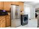 Spacious kitchen with stainless steel refrigerator, wooden cabinets, microwave and washer dryer combo at 143 W College St, Stanley, NC 28164