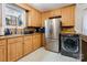 Well-lit kitchen with stainless steel appliances and wood cabinets, including washer dryer hookups at 143 W College St, Stanley, NC 28164