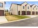 A townhouse with attached garages, neutral stucco, dark trim, and a small grass yard at 154 Shields Dr, Lincolnton, NC 28092