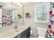 The bathroom features a vanity, a flower-patterned shower curtain, and a window with natural light at 1628 Rosegate Ln, Stanfield, NC 28163
