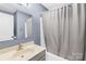 This bathroom features a vanity with a sink, a shower with a gray curtain, and a round mirror at 1628 Rosegate Ln, Stanfield, NC 28163