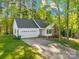 Charming single-story home with an attached two-car garage, lush lawn, and mature trees on a sunny day at 1628 Rosegate Ln, Stanfield, NC 28163