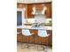 Modern kitchen island has white countertop, stylish pendant lights, seating, and walnut cabinetry detail at 233 Conifer Way, Shelby, NC 28150