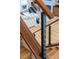 Modern staircase featuring hardwood steps, metal railing, and a glimpse into an open concept living area at 233 Conifer Way, Shelby, NC 28150