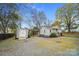 View of a storage shed and covered parking area in the backyard with gravel at 2420 Kannapolis Hwy, Concord, NC 28027