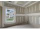 An image of a bedroom interior features bare drywall and view to neighborhood through window at 2508 Rock Dam Rd, Lincolnton, NC 28092