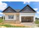 Newly built home with white siding, grey shingles, brick foundation, and an unfinished garage at 2508 Rock Dam Rd, Lincolnton, NC 28092