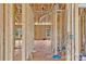 A framed hallway featuring stud walls, wiring, duct work and a view into the living room at 2508 Rock Dam Rd, Lincolnton, NC 28092