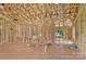 A framed living room featuring exposed ceiling beams, stud walls, window, wiring and some plumbing at 2508 Rock Dam Rd, Lincolnton, NC 28092