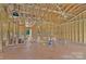 A spacious living room features exposed ceiling beams, stud walls, window, wiring, duct work and some plumbing at 2508 Rock Dam Rd, Lincolnton, NC 28092