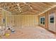 A framed living room featuring a window, door, open ceiling with wooden beams and wiring at 2508 Rock Dam Rd, Lincolnton, NC 28092