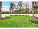 Spacious backyard with lush green grass, mature trees, and a white fence for privacy and outdoor enjoyment at 2510 Bricker Dr, Charlotte, NC 28273