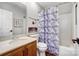 Bathroom with neutral colors has a single sink vanity, toilet, and shower with geometric shower curtain at 2510 Bricker Dr, Charlotte, NC 28273