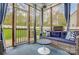 Sunroom features a wicker sofa with navy cushions, outdoor carpet and a doggie door at 2510 Bricker Dr, Charlotte, NC 28273