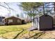 View of backyard featuring a storage shed, a lawn, and brick home construction at 2650 31St Street Ne Ct, Hickory, NC 28601