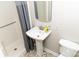 Well-lit bathroom with a pedestal sink, mirror, a shower, and toilet at 2650 31St Street Ne Ct, Hickory, NC 28601