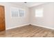 Bright bedroom with two windows, wood-look flooring, and neutral walls creating a calming atmosphere at 2650 31St Street Ne Ct, Hickory, NC 28601