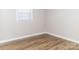 Corner of a bedroom with wood-look floors, a bright window, and neutral walls at 2650 31St Street Ne Ct, Hickory, NC 28601