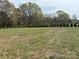 Sprawling backyard with lush green space and mature landscaping at 3012 Ocean Dr, Monroe, NC 28110
