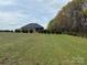 Expansive backyard with mature trees and lush green lawn at 3012 Ocean Dr, Monroe, NC 28110