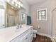 Well-lit bathroom featuring a white vanity, large mirror, and a glass-enclosed shower at 3012 Ocean Dr, Monroe, NC 28110