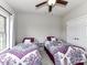 Bright bedroom featuring two twin beds, ceiling fan, and natural light from the window at 3012 Ocean Dr, Monroe, NC 28110