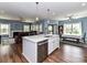 Open-concept kitchen with island seating, stainless steel appliances, and a seamless flow to the living and dining areas at 3012 Ocean Dr, Monroe, NC 28110