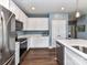 Modern kitchen featuring white cabinetry, stainless steel appliances, and a sleek countertop, offering a clean and functional space at 3012 Ocean Dr, Monroe, NC 28110