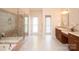 Well-lit bathroom with glass-enclosed shower, soaking tub, and double vanities at 3071 Ancestry Cir, Matthews, NC 28104