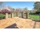 A cozy backyard stone patio with brick and iron fencing and beautiful landscaped greenery at 3071 Ancestry Cir, Matthews, NC 28104