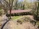 Expansive aerial view of a single-story home featuring a classic red roof and surrounded by lush greenery and mature trees at 340 Sardis N Rd, Charlotte, NC 28270