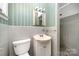This bathroom offers a shower, vanity and striped wallpaper at 340 Sardis N Rd, Charlotte, NC 28270