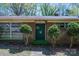Charming home exterior with a brick facade, symmetrically placed bushes, and a welcoming green door, presenting a classic look at 340 Sardis N Rd, Charlotte, NC 28270