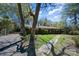 Features an angle shot of a brick home with a stone walkway, complemented by a tidy lawn and mature trees under a blue sky at 340 Sardis N Rd, Charlotte, NC 28270