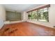 Hardwood flooring in a light-filled living room, featuring a large window and subtle, decorative wallpaper adding character at 340 Sardis N Rd, Charlotte, NC 28270
