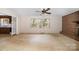 Living room featuring a brick fireplace, a large window, and view into the kitchen, blending comfort with functionality at 340 Sardis N Rd, Charlotte, NC 28270
